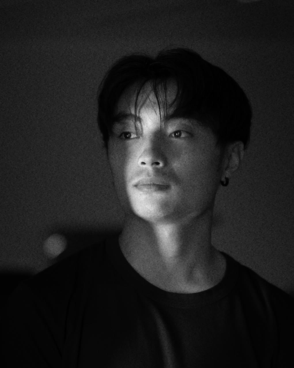 Jeremy Yeh in black and white, lit from one side against a dark room.